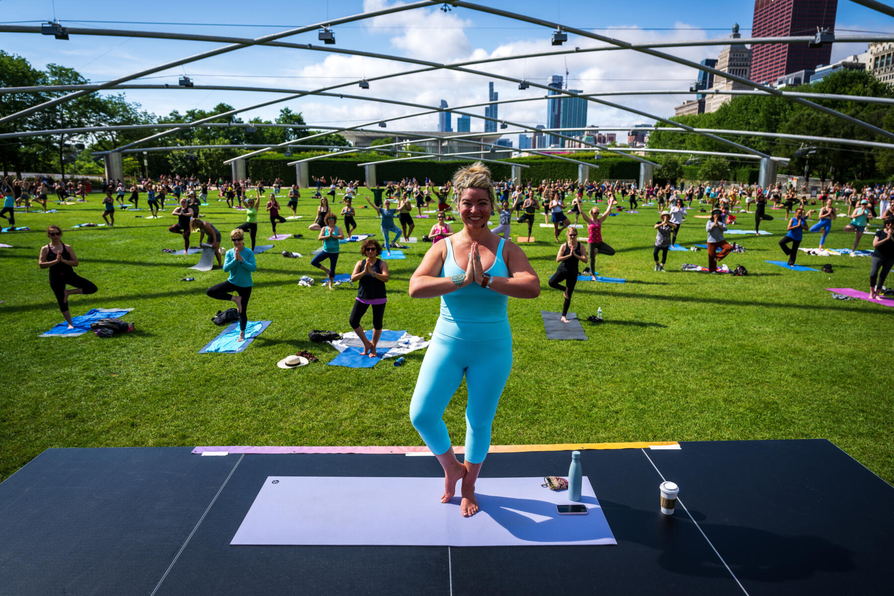 Residents doing yoga at Millennium Park Summer Workouts series at the Pritzker Pavilion in Chicago's Loop