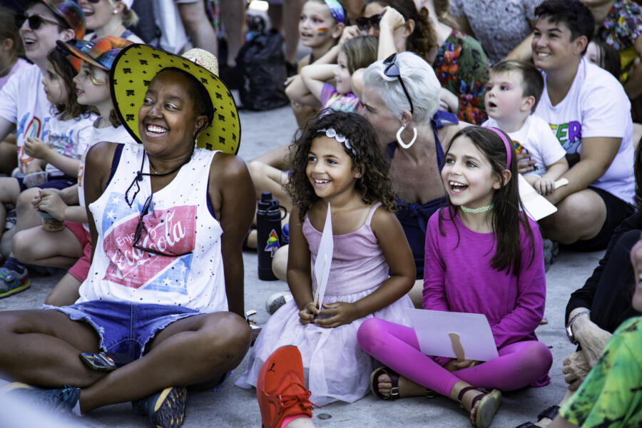 Families and children laughing and enjoying performances at the Queer Fam Pride Jam in Chicago, a family-friendly LGBTQ+ event.